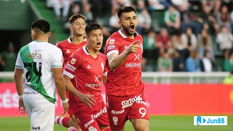 Cầu thủ của Huracan vượt qua phòng ngự của Banfield trong trận đấu bóng đá