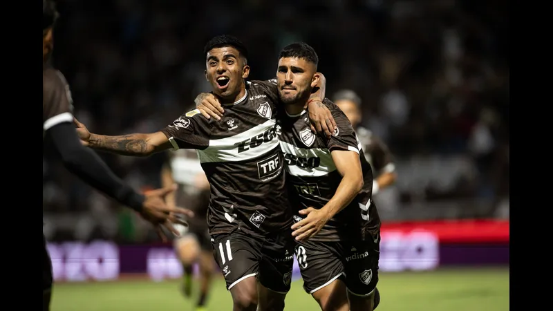 Cầu thủ của Platense dẫn bóng qua cầu thủ của Deportivo Riestra trong trận đấu giữa hai…